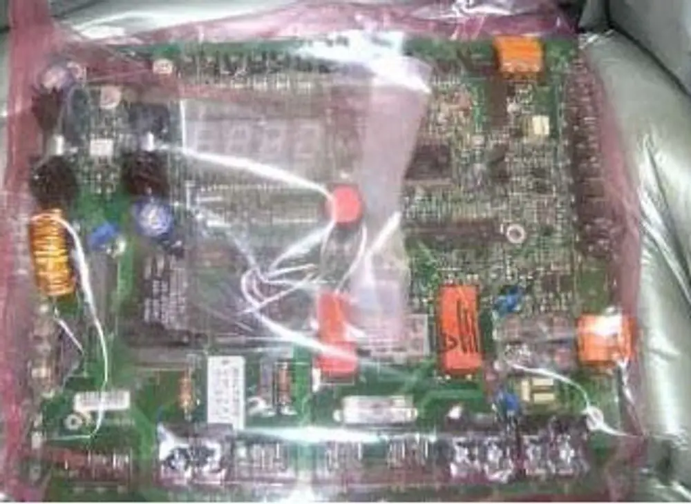 Elektronikplatine in transparenter Schutzverpackung, mit verschiedenen Komponenten und Anschlüssen, erkenntlich als Remeha-Produkt.
